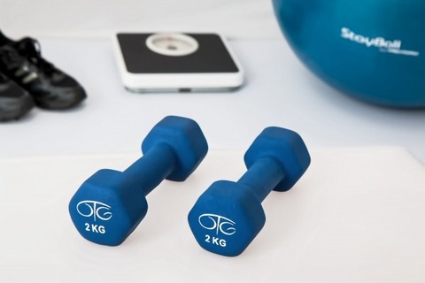 blue-dumbells-with-exercise-ball-and-scale-on-floor