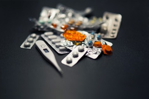 medicines-and-thermometer-on-black-background