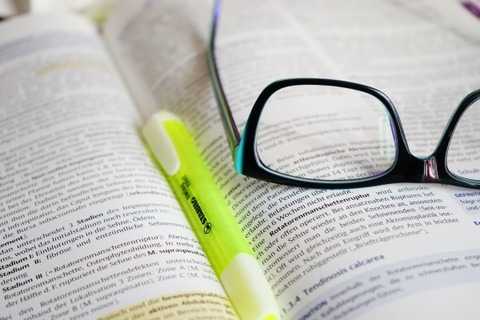 eyeglasses-and-highlighter-on-open-book